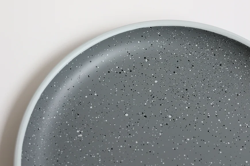 Rounded rim and speckled interior detail of stoneware-inspired serving tray