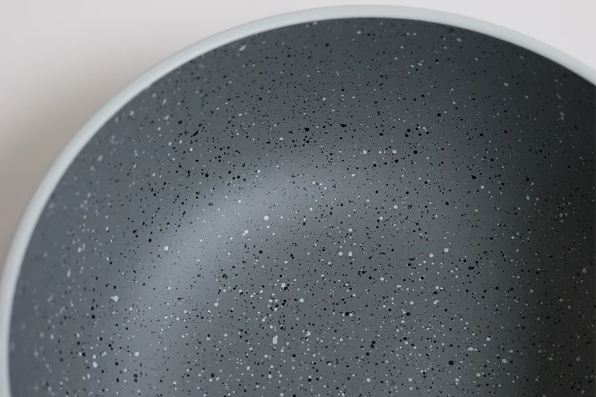 Curved speckled interior detail of stoneware-inspired recycled PET serving bowl